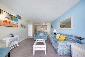 a living room with a couch and a table at Oceanfront Oasis 1002 in Abbeyville