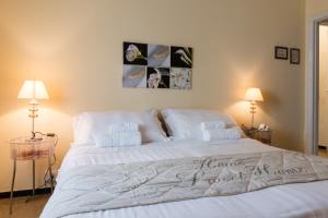 una camera da letto con un grande letto bianco con un cartello di casa di Hotel Eden ad Arenzano