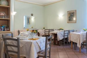 un comedor con mesas y sillas con mantel blanco en Hotel Eden, en Arenzano