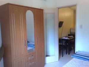 a bedroom with a large wooden cabinet with a mirror at Chateau Elysee in Manila