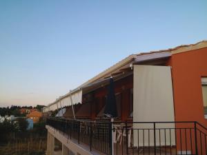 a balcony of a building with an umbrella on it at Christos Family Apartments Β in Ágios Rókkos