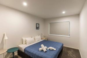 ein Schlafzimmer mit einem Bett mit zwei Stofftieren darauf in der Unterkunft Belle Vista - Luxury Canal Front Home near Theme Parks with Pool in Gold Coast