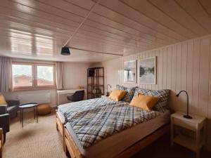 a bedroom with a bed and a chair in a room at Heimeliges Ferienhaus in Grüsch