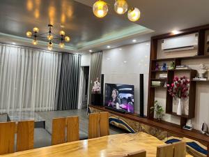 a living room with a dining table and a tv at Căn hộ 03 phòng ngủ tầng 8 Oasky view biển in Vung Tau