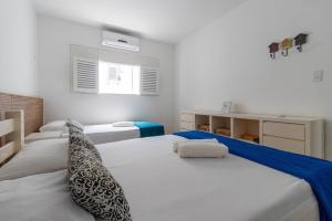 a white bedroom with two beds and a window at Casa beira-mar 25km do aeroporto de Recife in Cabo de Santo Agostinho +46 photos