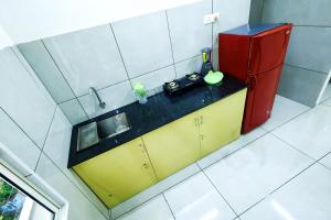 a small kitchen with a sink and a refrigerator at kallungal square - Edapally in Cochin