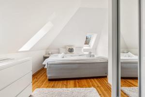 a white bedroom with two beds in a attic at Dinbnb Apartments I Historical Two-Floor Apartment with Rooftop Panorama I 1645 Heritage in Bergen