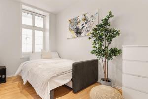 a bedroom with a bed and a potted plant at Dinbnb Apartments I 500m to Bryggen in Bergen