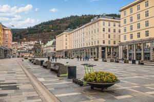 a city street with buildings and a pot of flowers at Dinbnb Apartments I 500m to Bryggen in Bergen
