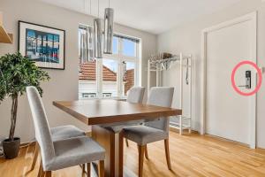 a dining room with a wooden table and chairs at Dinbnb Apartments I Historical Two-Floor Apartment with Rooftop Panorama I 1645 Heritage in Bergen +14 photos