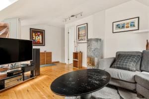 a living room with a couch and a table at Dinbnb Apartments I Historical Two-Floor Apartment with Rooftop Panorama I 1645 Heritage in Bergen