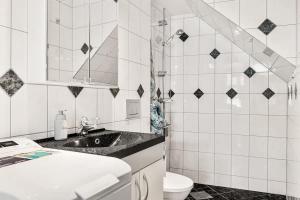 a white bathroom with a sink and a toilet at Dinbnb Apartments I Historical Two-Floor Apartment with Rooftop Panorama I 1645 Heritage in Bergen
