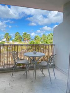 a table and chairs on a balcony with a view of the ocean at Éléa-Nore studio in Marigot