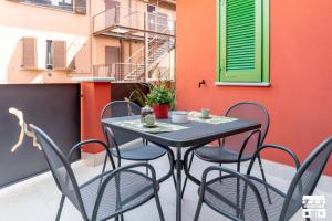 a black table and chairs on a balcony at CASA DEL LAGO by Design Studio in Bellano +27 photos