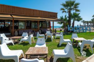 a group of chairs and tables in front of a building at Luxury beachfront 3BR in Nereidas with Pools Spa Gym in Torremolinos