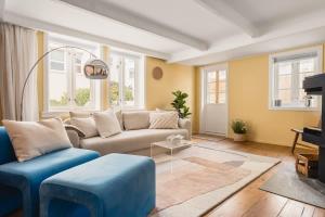 a living room with a couch and blue chairs at Dinbnb Homes I Bergen's #1 BNB I Jacuzzi & Fireplace & Balcony in Bergen