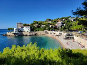 a beach with a group of people laying on the sand at Magnifique appartement Cassis in Cassis