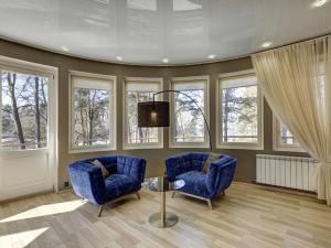 two blue chairs and a table in a room with windows at Narva-Jõesuu Medical Spa in Narva-Jõesuu