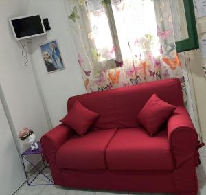 a red couch in a living room with a window at Casa Vacanza Arcobaleno in Oria