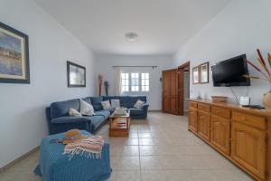 a living room with a blue couch and a tv at Casa Vlaorda by HH in Caleta de Sebo