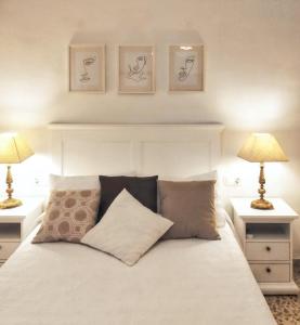 a bedroom with a white bed with two lamps at Charming villa near Córdoba with private pool in Encinarejo De Córdoba