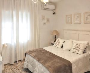 a white bedroom with a bed and a window at Charming villa near Córdoba with private pool in Encinarejo De Córdoba +21 photos