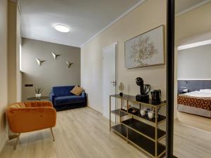 a living room with a bed and a blue chair at Narva-Jõesuu Medical Spa in Narva-Jõesuu