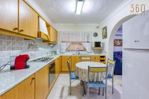 a kitchen with a table and chairs and a sink at Cosy and Spacious 3BR Apt in Bugibba's heart by 360 Estates in St Paul's Bay