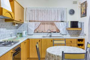 a kitchen with wooden cabinets and a sink and a window at Cosy and Spacious 3BR Apt in Bugibba's heart by 360 Estates in St Paul's Bay