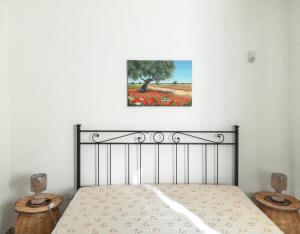 ムーロ・レッチェーゼにあるCharming House Muro Leccese + Terraceのベッドルーム1室(ランプ2つ、壁に絵画付)