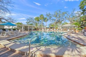 een groot zwembad met stoelen en een tafel bij Siesta Villa Whispering Palms in Siesta Key
