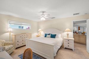 een slaapkamer met een wit bed en een stoel bij Siesta Villa Whispering Palms in Siesta Key +42 foto's