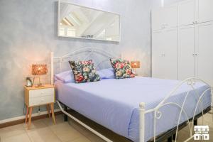 une chambre avec un lit avec des draps bleus et un miroir dans l'établissement M&P HOUSE by Design Studio, à Bellano