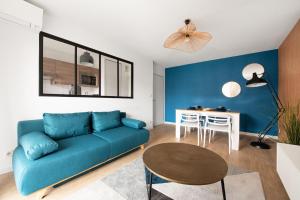 トゥールーズにあるChic T2 avec Balcon et Parking - Zénith, Hippodromeの青いソファとテーブルのあるリビングルーム