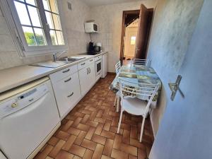 Plozévet697-Villa Hent Kost la mer a 10m的厨房里有一张桌子和几把椅子 更多22张照片