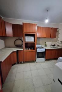 a kitchen with wooden cabinets and a microwave at Rincon Salteño Hostel in Salta