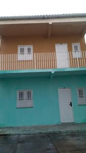 un edificio azul con puertas blancas y balcón en my sweet place 4, en São Luís