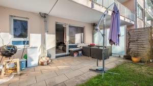 a patio with an umbrella and a living room at Ruhig in Munich