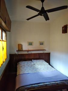 a bedroom with a bed with a ceiling fan at Los Duendes del Mar in San Clemente del Tuyú