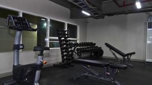 a gym with several exercise bikes and a phone at Mesavirre Garden Residences - Cozy Den in Bacolod