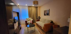 a living room with a couch and a tv at Rin Grand Residence 1 in Bucharest