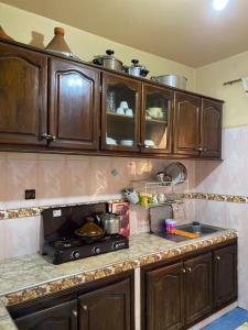 a kitchen with wooden cabinets and a stove top oven at Appartement meublé in Benguerir