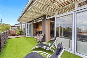 an outdoor patio with green grass and chairs at Exclusive 3-Bedroom Luxury Villa Cape Town CBD in Cape Town