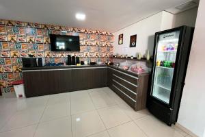 a food counter in a restaurant with a refrigerator at Hotel ROF in Telêmaco Borba