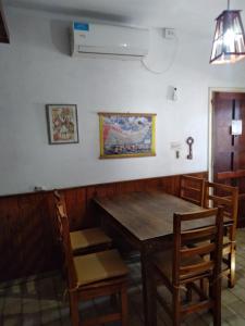 a dining room with a wooden table and chairs at Los Duendes del Mar in San Clemente del Tuyú