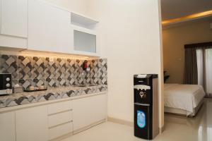 a kitchen with a refrigerator and a bed in a room at Gelis Gede Cottages in Uluwatu