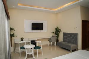 a living room with a table and a tv on the wall at Gelis Gede Cottages in Uluwatu
