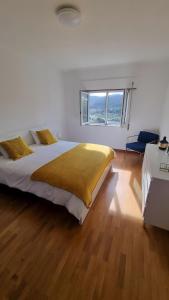 a bedroom with a large bed and a window at Retiro do Viajante in Penacova