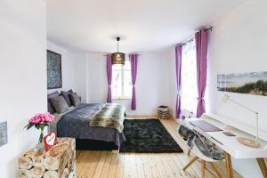 a bedroom with a bed with purple curtains and a desk at DesignLodge Apartments in Bad Sobernheim