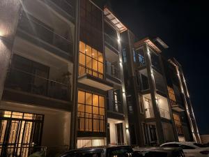a building with cars parked in front of it at night at Alphaton homez in Kampala